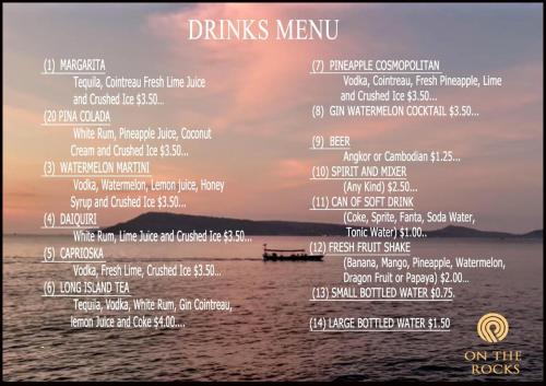 a menu for a drinks menu in front of the ocean at On the Rocks in Koh Rong Sanloem