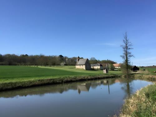 Blick auf einen Fluss mit einem Haus im Hintergrund in der Unterkunft La Chapelle - Campagne - 8pers - Rêve au Mans in Thorée-les-Pins