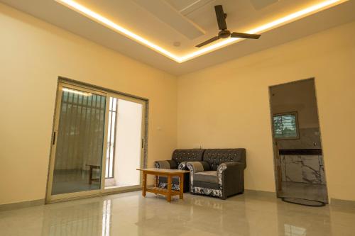 sala de estar con sofá y ventilador de techo en Shiv Shakti Homestay en Ujjain