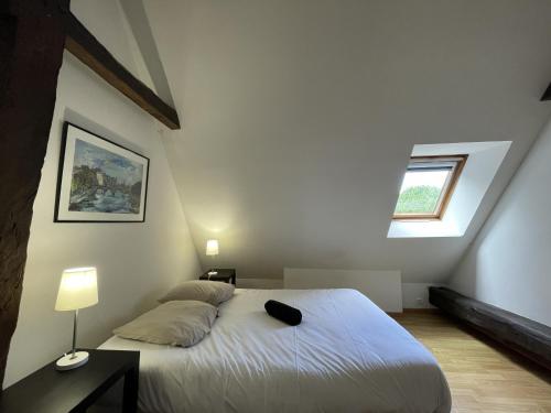 1 dormitorio con 1 cama blanca y ventana en La Boulangerie - Campagne - 6 pers - Rêve au Mans, en Thorée-les-Pins