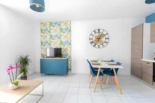 une cuisine avec une table, des chaises et une horloge dans l'établissement Le Camélia - Parking - 5pers - Rêve Au Mans, au Mans