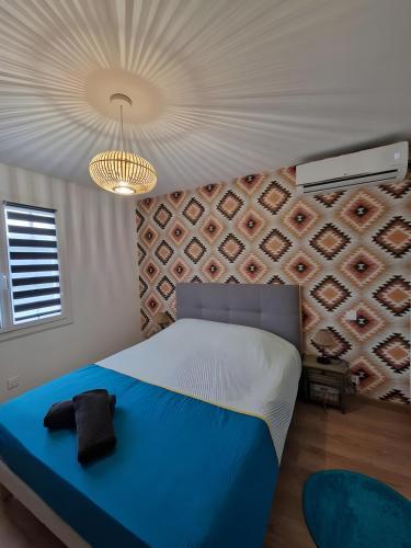 ein Schlafzimmer mit einem großen Bett mit einer blauen Decke in der Unterkunft Le Phénix - Piscine chauffée - 7pers- Rêve au Mans in La Suze-sur-Sarthe