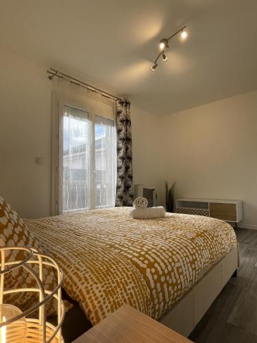 um quarto com uma cama grande e uma janela em La Feuillette - Cosy - Wifi - 4 personnes - Rêve au Mans em Pontlieue