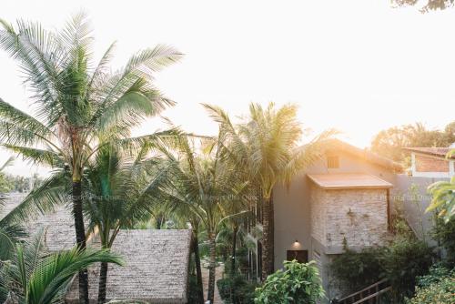 a group of palm trees in front of a house at M Village Phu Quoc in Phu Quoc