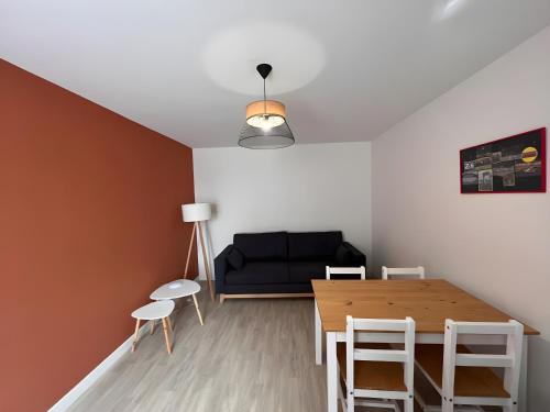 un salon avec un canapé noir et une table dans l'établissement Les 24h du Mans - Campagne - 4pers - Rêve au Mans, à Saint-Mars-sous-Ballon