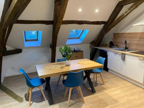 eine Küche und ein Esszimmer mit einem Holztisch und blauen Stühlen in der Unterkunft Le Contemporain - 5p - Centre Ecommoy - Rêve au Mans in Écommoy