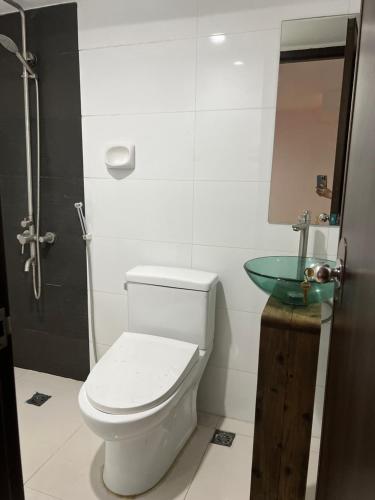 a bathroom with a toilet and a glass sink at Quinn Dormittelle in Manila