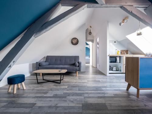 Una sala de estar con un sofá azul y una mesa. en Liris - Hyper Centre - Wifi - 4 personnes - Rêve au Mans, en Le Mans