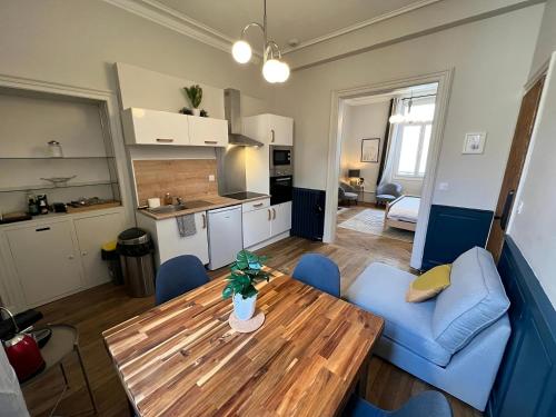 a living room with a wooden table and a kitchen at Le Nomade - Gare - 3 pers - Rêve au Mans in Le Mans