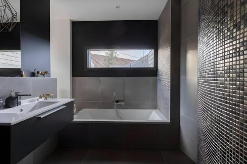 La salle de bains est pourvue d'une baignoire et d'un lavabo. dans l'établissement Le Dolce - Piscine - Jardin - 8pers - Rêve au Mans, à Coulaines
