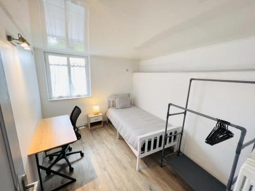 um pequeno quarto com uma cama e uma secretária em Le Lodge - Cosy - Wifi - 4 personnes - Rêve au Mans em Connerré