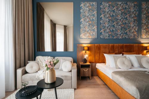 een slaapkamer met een bed, een bank en een tafel bij White Lotus - LoftAffair Collection in Krakau