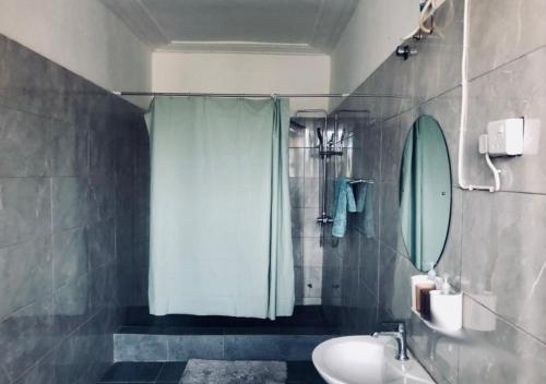 een badkamer met een douche, een wastafel en een toilet bij Access Inn in Accra