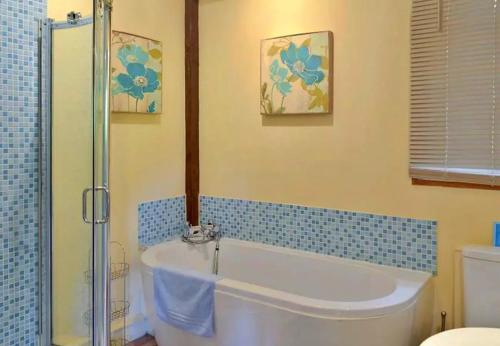 a bathroom with a bath tub and a shower at Finest Retreats - Little Dunley - Acorn Cottage in Bovey Tracey