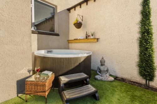 a bath tub in a yard next to a building at Ellerthwaite Place X3 Bed House with Hot Tub in Central Windermere in Windermere