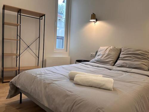 Una cama con una toalla blanca encima. en Appartement 4 lits • Tout neuf, en Montreuil