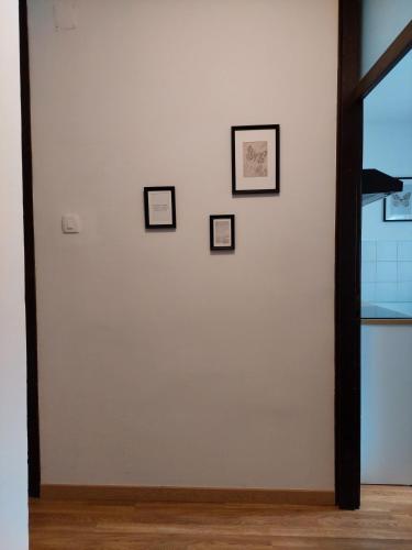 a white wall with four pictures on it at M&M Apartment in Velika Gorica