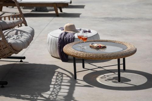 a table with a glass of wine and a hat at Mandilaras Village in Vívlos