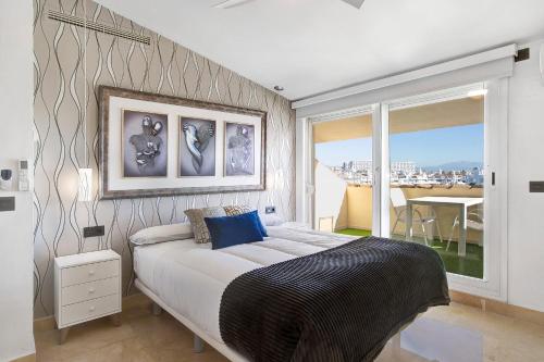 a bedroom with a large bed and a balcony at Luxury in Puerto Marina in Benalmádena