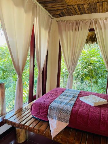 a bedroom with a bed and a window at Pu Luong Jungle Lodge in Pu Luong