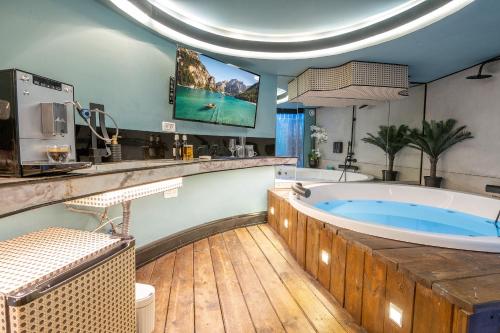 a large bathroom with a large tub and a tv at A place to relax - חדרי אירוח מקסימים עם ג'קוזי פרטי בשכונת תלפיות בירושלים in Yerushalayim