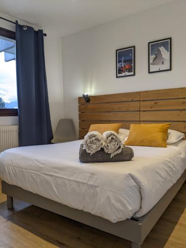 une chambre avec un grand lit avec une tête de lit en bois dans l'établissement le Fier Pied à terre à Annecy, à Annecy