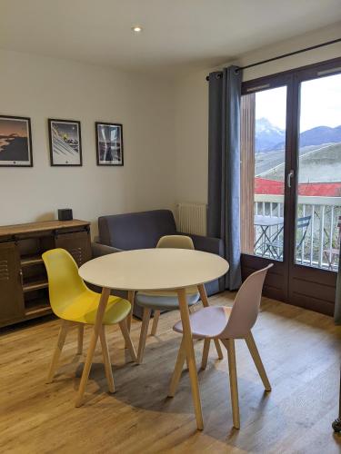 une table et des chaises dans une pièce avec une fenêtre dans l'établissement le Fier Pied à terre à Annecy, à Annecy