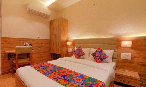 een slaapkamer met een bed en een bureau. bij FabHotel Pratham Inn in Chinhat
