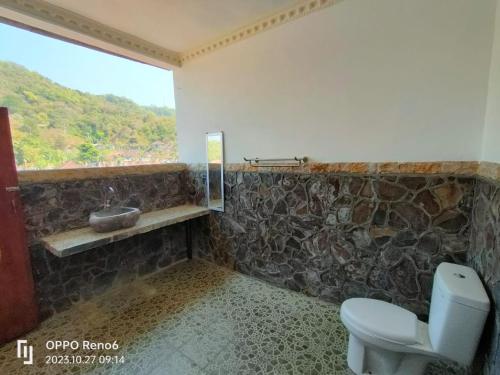 a bathroom with a toilet and a window at Dharma homestay in Padangbai