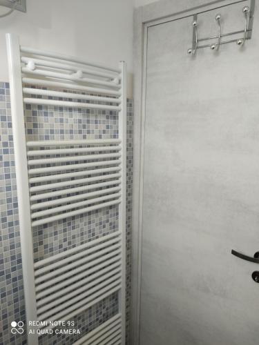 a white shower door in a bathroom next to a wall at Il cortiletto in Vado Ligure