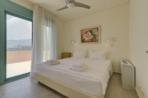 a bedroom with a bed and a large window at Ouzo Panoramic Houses 1, with private pool in Plomari