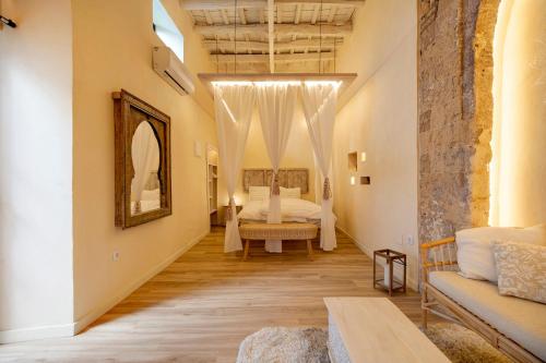 Private Spa in Kangen House Jerez في خيريز دي لا فرونتيرا: غرفة نوم بسرير واريكة في غرفة
