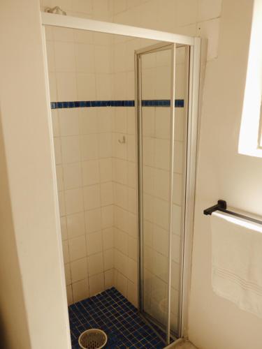 a shower with a glass door in a bathroom at Villa Viva Cape Town in Cape Town