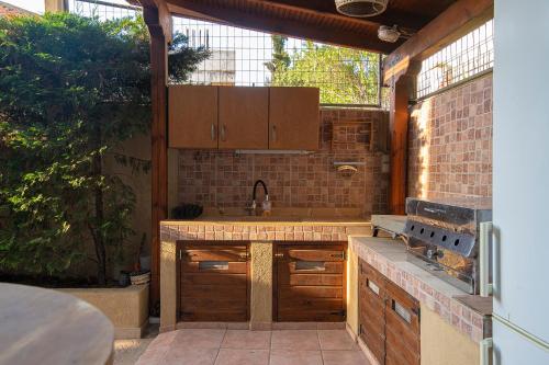 an outdoor kitchen with wooden cabinets and a sink at Flow Garden Pool Villa, Gerakini Halkidiki in Gerakini