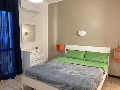 um quarto com uma cama com lençóis verdes em B&B RosAngelo em Mirabella Imbaccari