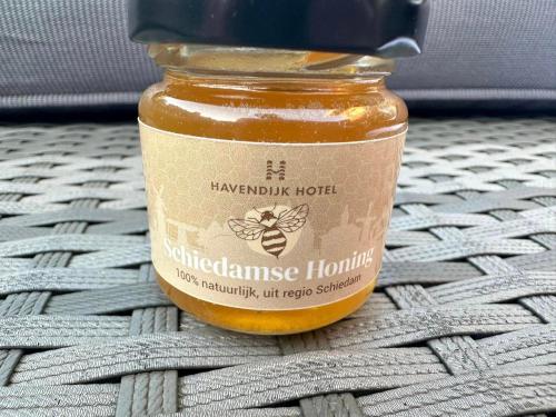a jar of honey sitting on a table at Havendijk Hotel in Schiedam