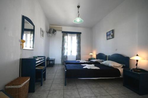 a bedroom with two beds and a desk and a mirror at Deep Blue Studios in Logaras