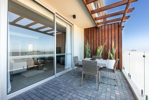 a patio with a table and chairs on a balcony at The Pearls Swakopmund in Swakopmund