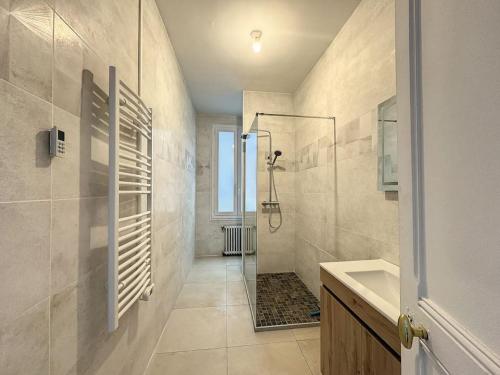 y baño con ducha y lavamanos. en La Maison de Fayza - 11 personnes en Bourganeuf