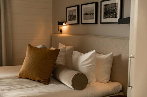 a bed with white pillows and a brown pillow at Slottsholmen Hotell och Restaurang in Västervik