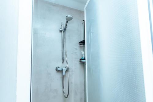a shower in a bathroom with a glass door at Barcelona & You Hostel Sagrada Familia in Barcelona