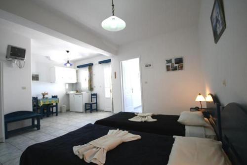 a bedroom with two beds and a living room at Deep Blue Studios in Logaras