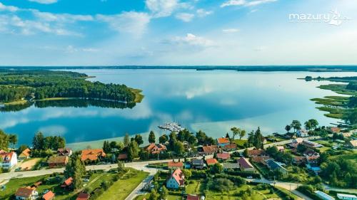 z powietrza widok na małe miasteczko nad jeziorem w obiekcie Mazurska Apartamenty w Rydzewie