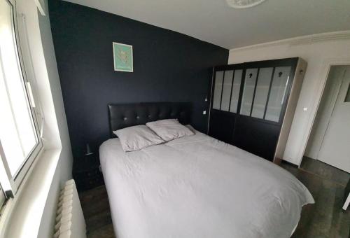 1 dormitorio con cama blanca y pared negra en Appart hyper centre La Baule - Balcon vue dégagée, en La Baule