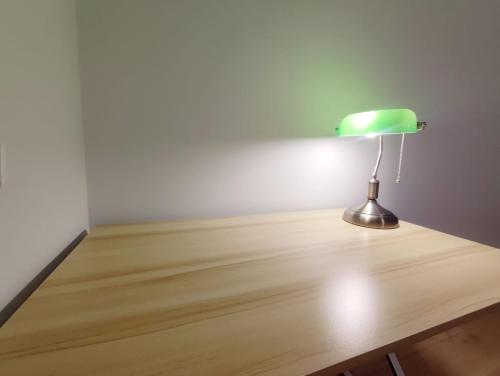 uma lâmpada verde sentada em cima de uma mesa de madeira em Silesia Comforts Katowice, Chorzów SELF CHECK em Chorzów
