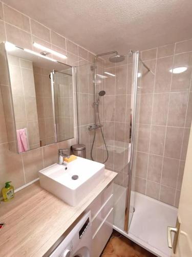 une salle de bain avec un lavabo blanc et une douche dans l'établissement Petit paradis avec jardin et clim T2, à Saint-Mandrier-sur-Mer