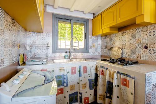 uma cozinha com armários amarelos, um lavatório e um fogão em Studio Rooftop em Tânger