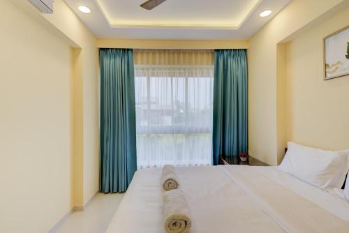a bedroom with a large bed and a window at Luxe 2BHK 10min from GOI airport with Pool access in Dabolim