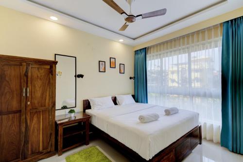 um quarto com uma cama grande e uma janela em Luxe 2BHK by Coral BnB with Pool access em Dabolim
