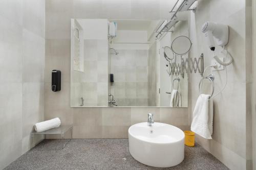 a white bathroom with a sink and a mirror at Luxe 2BHK 10min from GOI airport with Pool access in Dabolim